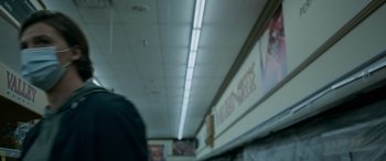 Movie still from “Sick” (2022), directed by John Hyams – A person walking down the aisle of a store; Extreme Close Up shot, Low angle
