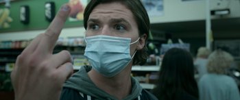 Movie still from “Sick” (2022), directed by John Hyams – A man wearing a face mask in a grocery store; Close Up shot, Low angle