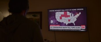 Movie still from “Sick” (2022), directed by John Hyams – A television screen with a map of the united states on it; Extreme Wide shot, High angle