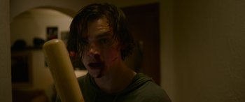 Movie still from “Sick” (2022), directed by John Hyams – A man with a knife in his mouth; Close Up shot, Low angle