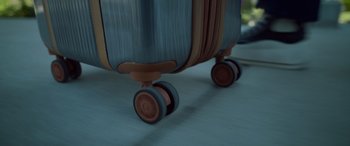 Movie still from “Sick” (2022), directed by John Hyams – View of the wheels of a suitcase; Extreme Close Up shot, Overhead angle