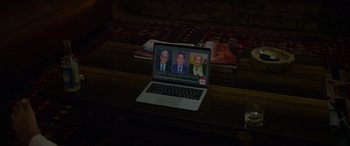 Movie still from “Sick” (2022), directed by John Hyams – An open laptop computer sitting on top of a wooden table; Medium shot, High angle