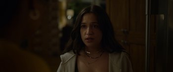 Movie still from “Sick” (2022), directed by John Hyams – A woman with long brown hair wearing a white jacket; Close Up shot, Over the shoulder angle