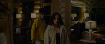 Movie still from “Sick” (2022), directed by John Hyams – A man and a woman standing next to each other in a room; Medium shot, Low angle