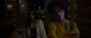 Movie still from “Sick” (2022), directed by John Hyams – Two women wearing face masks in a dark room; Close Up shot, Over the shoulder angle