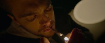 Movie still from “Sick” (2022), directed by John Hyams – A man smoking a cigarette while looking at a cell phone; Extreme Close Up shot, Low angle