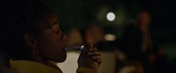 Movie still from “Sick” (2022), directed by John Hyams – A person is smoking a cigarette in the dark; Extreme Close Up shot, Low angle