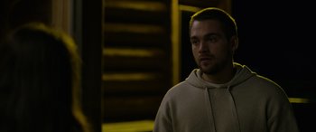 Movie still from “Sick” (2022), directed by John Hyams – A man in a hoodie stares into the distance; Close Up shot, Over the shoulder angle