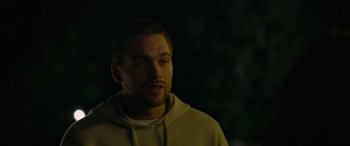 Movie still from “Sick” (2022), directed by John Hyams – A person wearing a hooded sweatshirt; Close Up shot, Over the shoulder angle