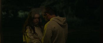 Movie still from “Sick” (2022), directed by John Hyams – A man and a woman standing next to each other in the dark; Medium shot, Over the shoulder angle