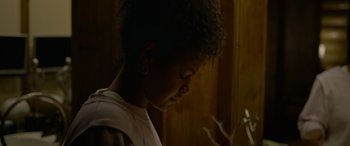 Movie still from “Sick” (2022), directed by John Hyams – A young woman is looking down at a flower; Close Up shot, Low angle