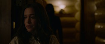 Movie still from “Sick” (2022), directed by John Hyams – A woman in a white shirt and a man in a black mask in the background; Close Up shot, Over the shoulder angle