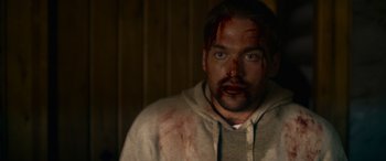 Movie still from “Sick” (2022), directed by John Hyams – A person with blood all over his face; Close Up shot, Over the shoulder angle