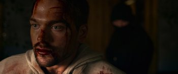 Movie still from “Sick” (2022), directed by John Hyams – A person with blood all over his face; Close Up shot, Over the shoulder angle