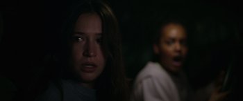 Movie still from “Sick” (2022), directed by John Hyams – A woman with long brown hair stares into the camera; Close Up shot, Over the shoulder angle