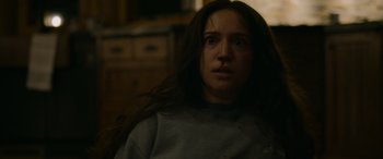 Movie still from “Sick” (2022), directed by John Hyams – A woman with long dark hair is looking at the camera; Close Up shot, Low angle