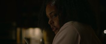 Movie still from “Sick” (2022), directed by John Hyams – A person with long black hair is looking to the side; Close Up shot, Over the shoulder angle