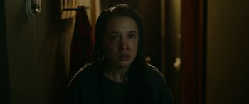 Movie still from “Sick” (2022), directed by John Hyams – A woman with long black hair is crying in a dark room; Close Up shot, Over the shoulder angle