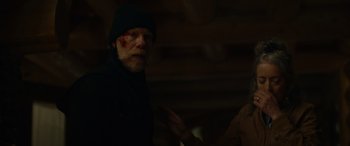 Movie still from “Sick” (2022), directed by John Hyams – A man in a black jacket and a black hat; Close Up shot, Over the shoulder angle