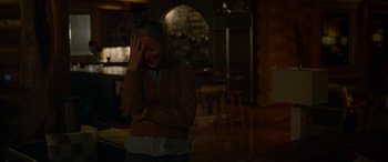 Movie still from “Sick” (2022), directed by John Hyams – A woman holding her head in her hands; Medium shot, Over the shoulder angle