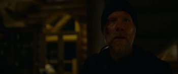 Movie still from “Sick” (2022), directed by John Hyams – A man with a beard wearing a black hat; Close Up shot, Low angle
