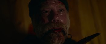 Movie still from “Sick” (2022), directed by John Hyams – A person with a beard and a hat on; Close Up shot, High angle