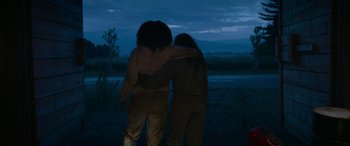 Movie still from “Sick” (2022), directed by John Hyams – Two people are hugging in the dark; Wide shot, Low angle