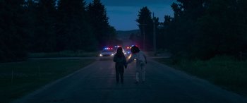 Movie still from “Sick” (2022), directed by John Hyams – Two people holding hands while walking down the street; Wide shot, Over the shoulder angle