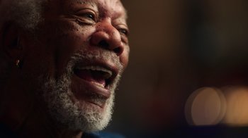 Movie still from “Sidney” (2022), directed by Reginald Hudlin – An old man with a beard and a white mustache is smiling; Close Up shot, Low angle