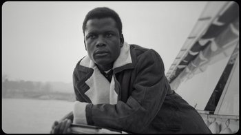 Movie still from “Sidney” (2022), directed by Reginald Hudlin – A black and white photo of a man leaning on a ladder; Close Up shot, Low angle