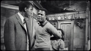 Movie still from “Sidney” (2022), directed by Reginald Hudlin – Two men and a woman in a room; Medium shot, Over the shoulder angle