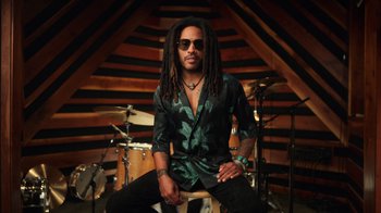 Movie still from “Sidney” (2022), directed by Reginald Hudlin – A man sitting on top of a stool in front of a drum set; Medium shot, Low angle