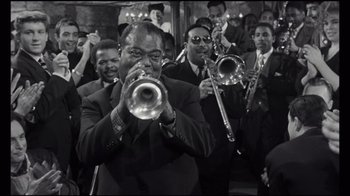 Movie still from “Sidney” (2022), directed by Reginald Hudlin – A black and white photo of a group of men playing trumpets; Medium shot, High angle