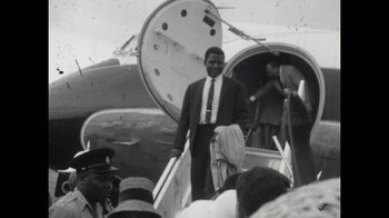 Movie still from “Sidney” (2022), directed by Reginald Hudlin – A black and white photo of a man exiting an airplane; Medium shot, Low angle