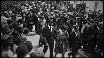 Movie still from “Sidney” (2022), directed by Reginald Hudlin – A black and white photo of a crowd of people; Extreme Wide shot, High angle