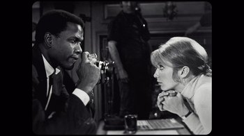 Movie still from “Sidney” (2022), directed by Reginald Hudlin – A black and white photo of a man and a woman; Close Up shot, Over the shoulder angle