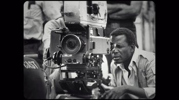 Movie still from “Sidney” (2022), directed by Reginald Hudlin – A black and white photo of a man looking at a camera; Close Up shot, Low angle