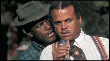 Movie still from “Sidney” (2022), directed by Reginald Hudlin – Two men are posing for a picture while one of them is holding a tie; Close Up shot, Low angle