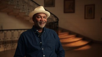 Movie still from “Sidney” (2022), directed by Reginald Hudlin – A man wearing a white hat and a blue shirt; Medium shot, Low angle