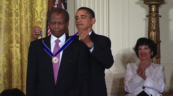 Movie still from “Sidney” (2022), directed by Reginald Hudlin – President barack obama standing next to an african - american man in front of the white house; Medium shot, Low angle