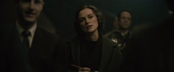 A woman in a green coat is holding a brush