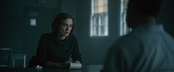 A woman sitting at a table in a dark room