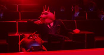 Movie still from “Sing 2” (2021), directed by Christophe Lourdelet – A man in a suit sitting next to a cat in a red room; Medium shot, Over the shoulder angle