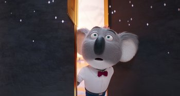 Movie still from “Sing 2” (2021), directed by Christophe Lourdelet – A stuffed koala standing in front of a door; Medium shot, Low angle