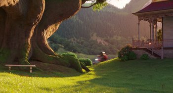 Movie still from “Sing 2” (2021), directed by Christophe Lourdelet – A person riding a motorcycle on a lush green hillside; Extreme Wide shot, Low angle