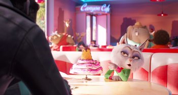Movie still from “Sing 2” (2021), directed by Christophe Lourdelet – A cat sitting in front of a cake on top of a table; Medium shot, Over the shoulder angle