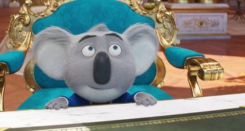 Movie still from “Sing 2” (2021), directed by Christophe Lourdelet – A cartoon koala sitting at a table in a chair; Medium shot, Low angle