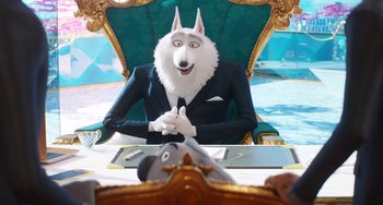 Movie still from “Sing 2” (2021), directed by Christophe Lourdelet – A man in a suit sitting at a table with a dog; Wide shot, High angle