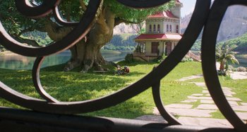 Movie still from “Sing 2” (2021), directed by Christophe Lourdelet – A view of a house and a tree through a fence; Extreme Wide shot, High angle