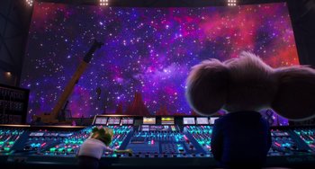 Movie still from “Sing 2” (2021), directed by Christophe Lourdelet – Two people in front of a large screen with a sky filled with stars; Wide shot, Low angle